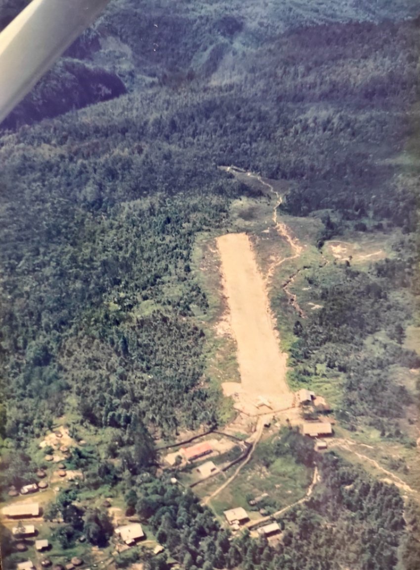 Steep airstrip - additional research indicates this is Holuwon. This strip, with an extreme 16% upslope, was where we had to jockey around the plane seen parked on the top end.