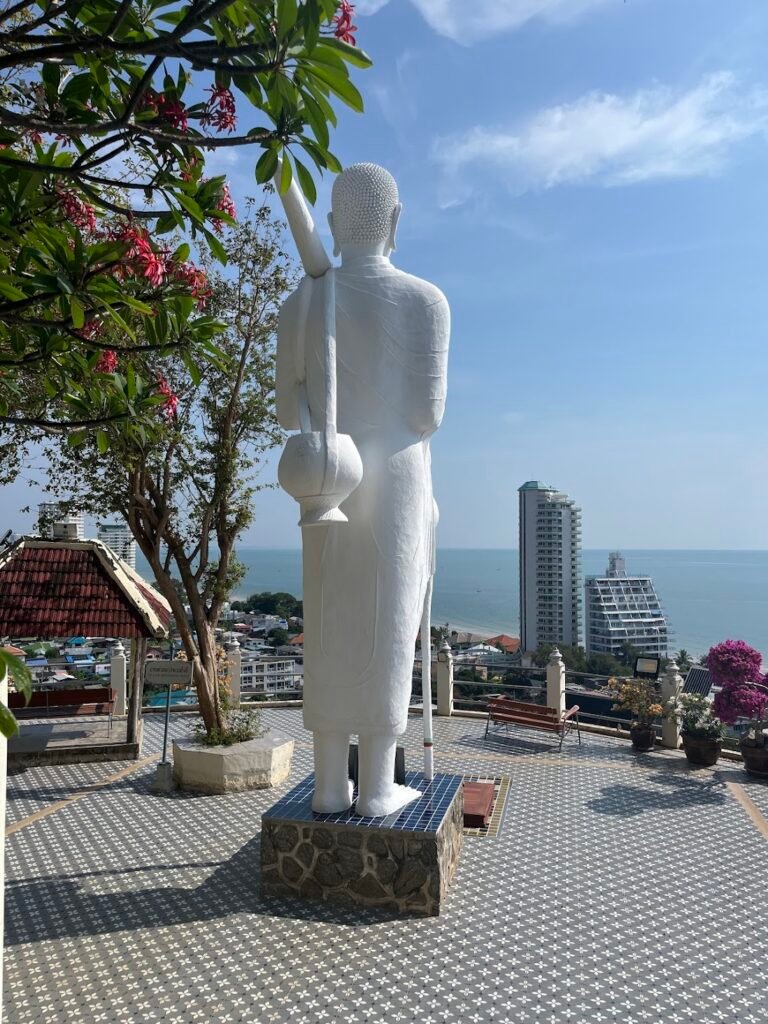 Not Buddha, but Phra Sivali, a highly revered arahant (a disciple of the Buddha) known as the patron saint of fortune, abundance, and safe travel. Looking out to sea to the north at Wat Khao Tapiap, Thailand.
