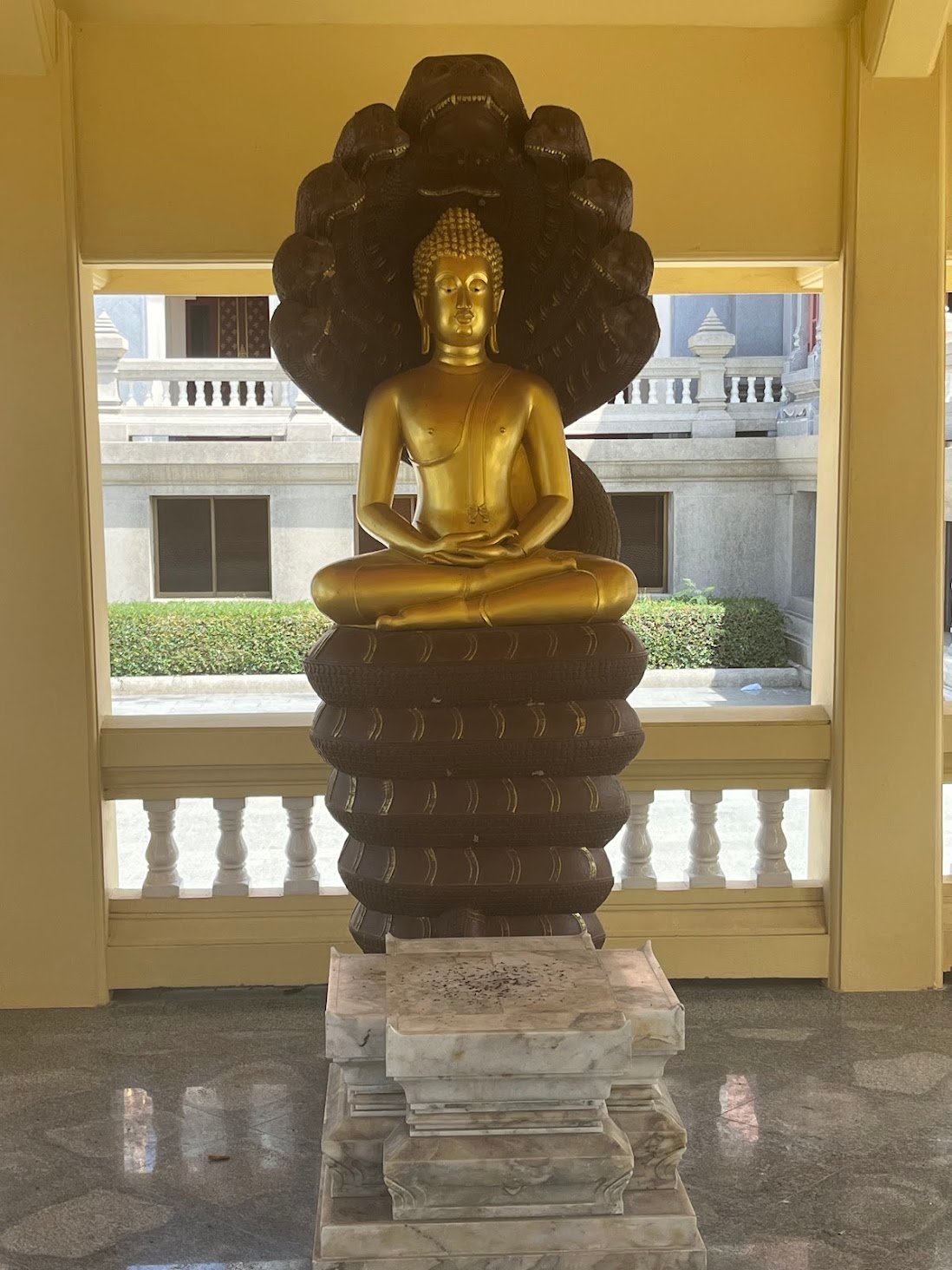 Buddha, king of the Nagas at Phra Maha Chedi Phakdi Phrakart, near Ban Krut, Thailand. He stares northwards across the trees to the ocean.