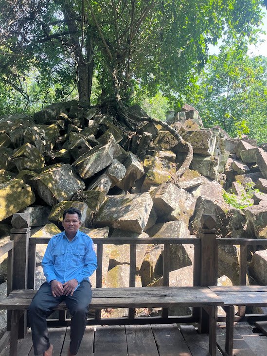 Beng Mealea temple, Cambodia. A friendly guard watches over a huge pile of rubble.