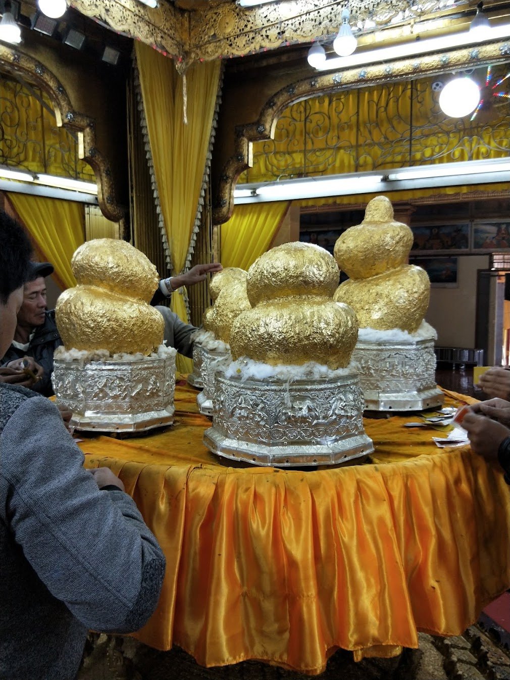 Phaung Daw Oo Pagoda on the southern shore of Inle Lake, Myanmar. These Buddha statues have been covered with so much accumulated gold leaf that they are just blobs. But still the people come and paste their thin pieces of gold.