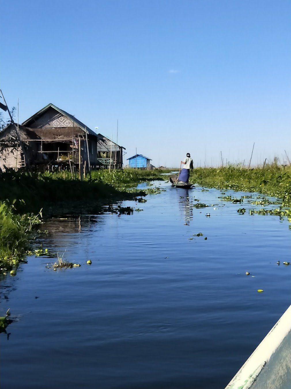 An Intha woman balances on her canoe in a floating village on Inle Lake, Myanmar.